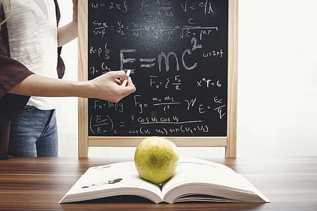 Teacher teaching and writes mathematical equations on the blackboard. Education and School concept. thumbnail