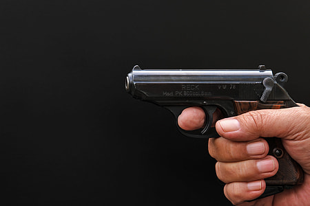 person holding black and brown semi-automatic pistol thumbnail