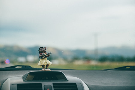 tilt shift lens photography of woman playing guitar figurine decor thumbnail