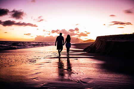 man and woman walking in coastline while holding each others hand thumbnail