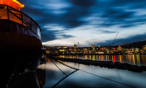 city lights reflecting on body of water at night thumbnail