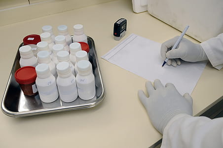 person wearing white disposable gloves and holding white ballpoint pen thumbnail
