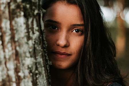 woman peeks from tree trunk thumbnail
