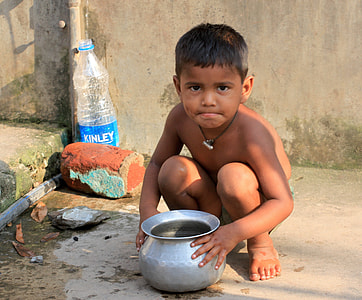 topless boy holding gray stainless steel spittoon while sitting thumbnail
