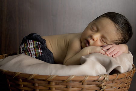 baby sleeping on gray bed inside gray room thumbnail