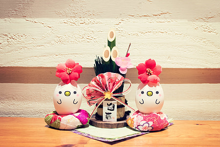 two decorative eggs in between potted bamboo with pink floral hand fan thumbnail