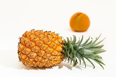 selective focus photography of ripe pineapple with orange fruit background thumbnail