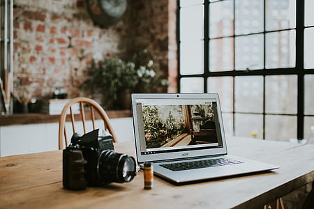black DSLR camera beside gray laptop computer thumbnail