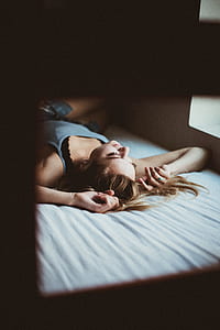woman lying on bed inside room thumbnail