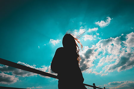 silhouette of woman under semi cloudy sky thumbnail