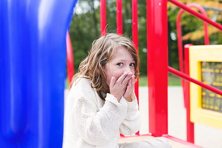 Little Girl Laughing Behind Hands Photo thumbnail