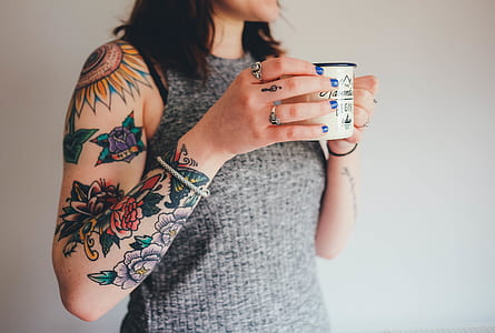 woman holding white mug white standing infront of white painted wall thumbnail