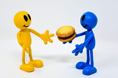 blue person figurine giving yellow person figurine hamburger thumbnail