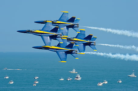 white ship under four blue-and-yellow fighting plane during during daytime thumbnail