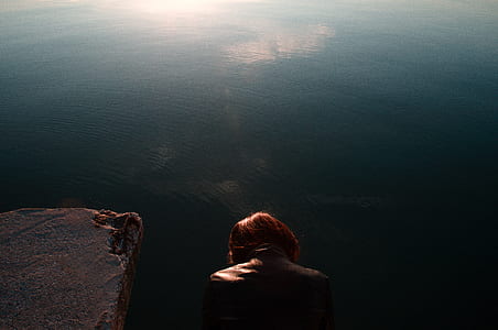 woman in brown leather jacket on cliff thumbnail
