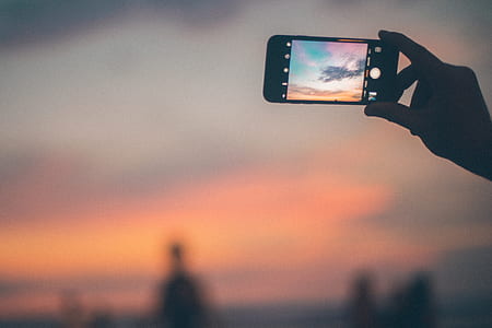 selective focus photography of person taking photo of sky thumbnail