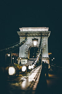 people on concrete arch bridge at nighttime thumbnail