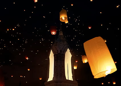 paper lanterns floating on nightime sky thumbnail