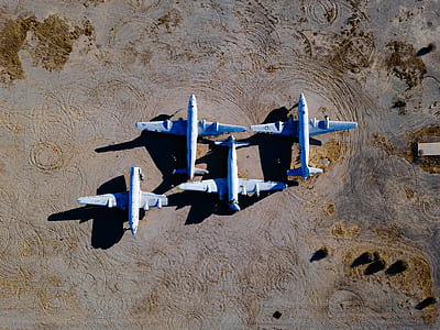 four white airplanes on ground during daytime thumbnail