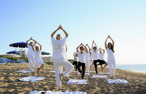 people wearing white shirts exercising on sea shore thumbnail
