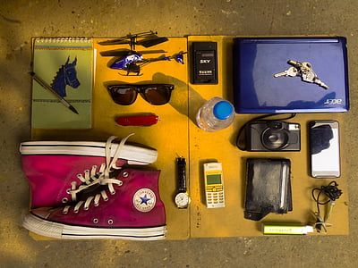 flat lay photography of laptop, camera, watch, high-top sneakers, steno notebook, and candybar phone thumbnail