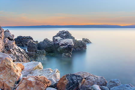 landscape photography of rock formations on body of water thumbnail