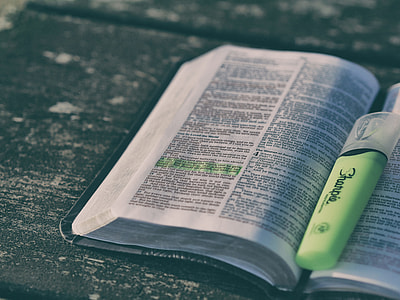 open bible with lighted marker on wooden panel thumbnail