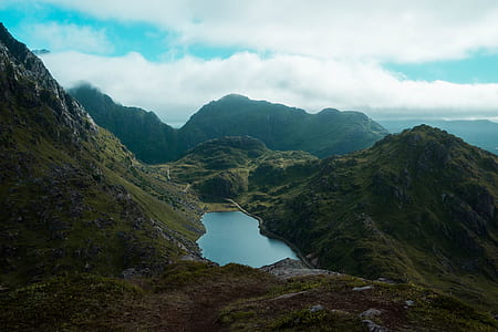 body of water between mountain with cloudy sky thumbnail