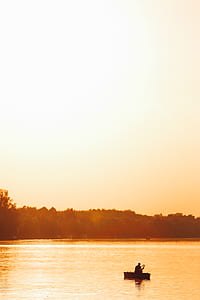 silhouette of person in boat on the middle of body of water thumbnail