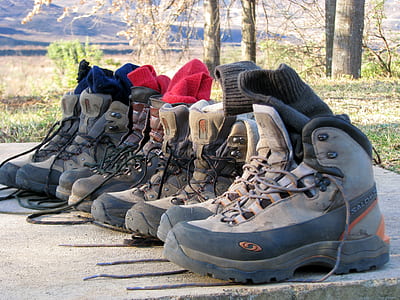 assorted pairs of hiking shoes on concrete pavement thumbnail
