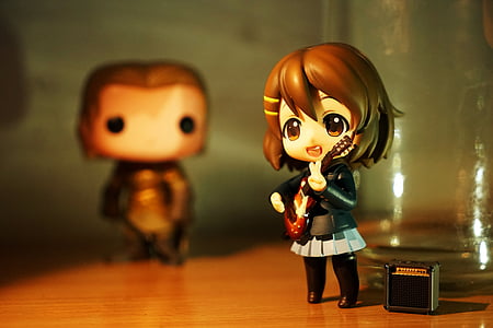 female brunette anime character playing guitar figurine on brown wooden surface thumbnail