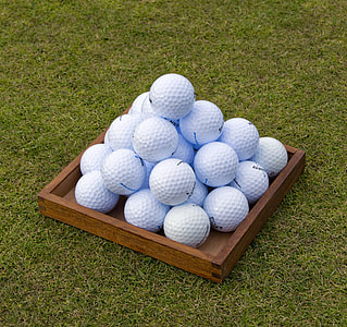 pile of white golf balls on grass field thumbnail