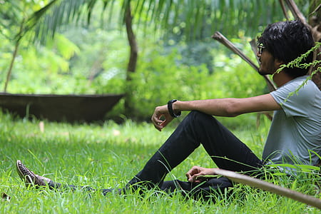 man in gray t-shirt sitting on green grass thumbnail