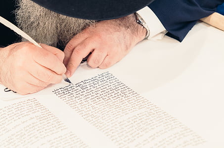 person in blue pants writing on white printer paper thumbnail