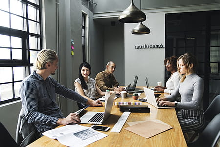 Five Person Sitting Front of Conference Table With Laptop Computers thumbnail