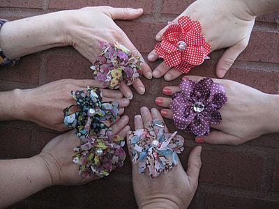 six hands laying on concrete brick with rosette rings thumbnail