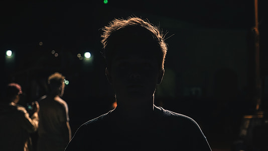 man standing near two person during nighttime thumbnail