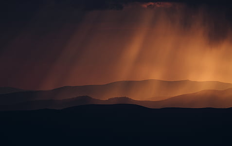 silhouette of mountain under crepuscular clouds thumbnail