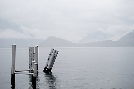 white metal post on body of water near mountain at daytime thumbnail