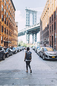 woman walking on road between buildings thumbnail