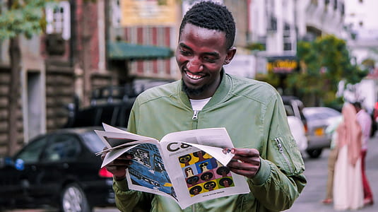 man holding magazine while smiling thumbnail