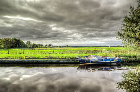 White and Blue Power Boat on Body of Water Under Clouds thumbnail
