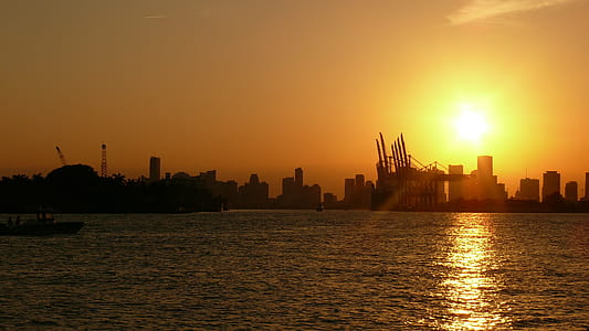 Silhouette of Buildings Near Body of Water Under Golden Hour thumbnail
