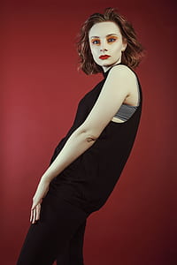 woman leaning back while wearing black dress thumbnail