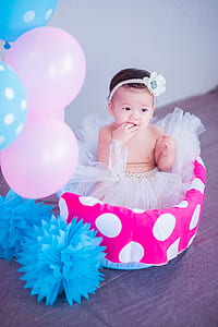 toddler on bed with balloons thumbnail