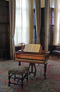 brown wooden piano with empty square ottoman chair inside room thumbnail