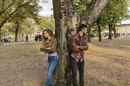 Man and Woman Wearing Leather Jackets Standing Under Tree thumbnail