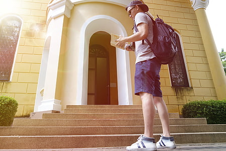 man standing bear building while holding book while thumbnail
