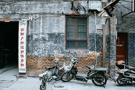 three motorcycles parked beside gray wall thumbnail