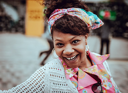 selective focus photo of woman in white crocheted top smiling at plaza thumbnail